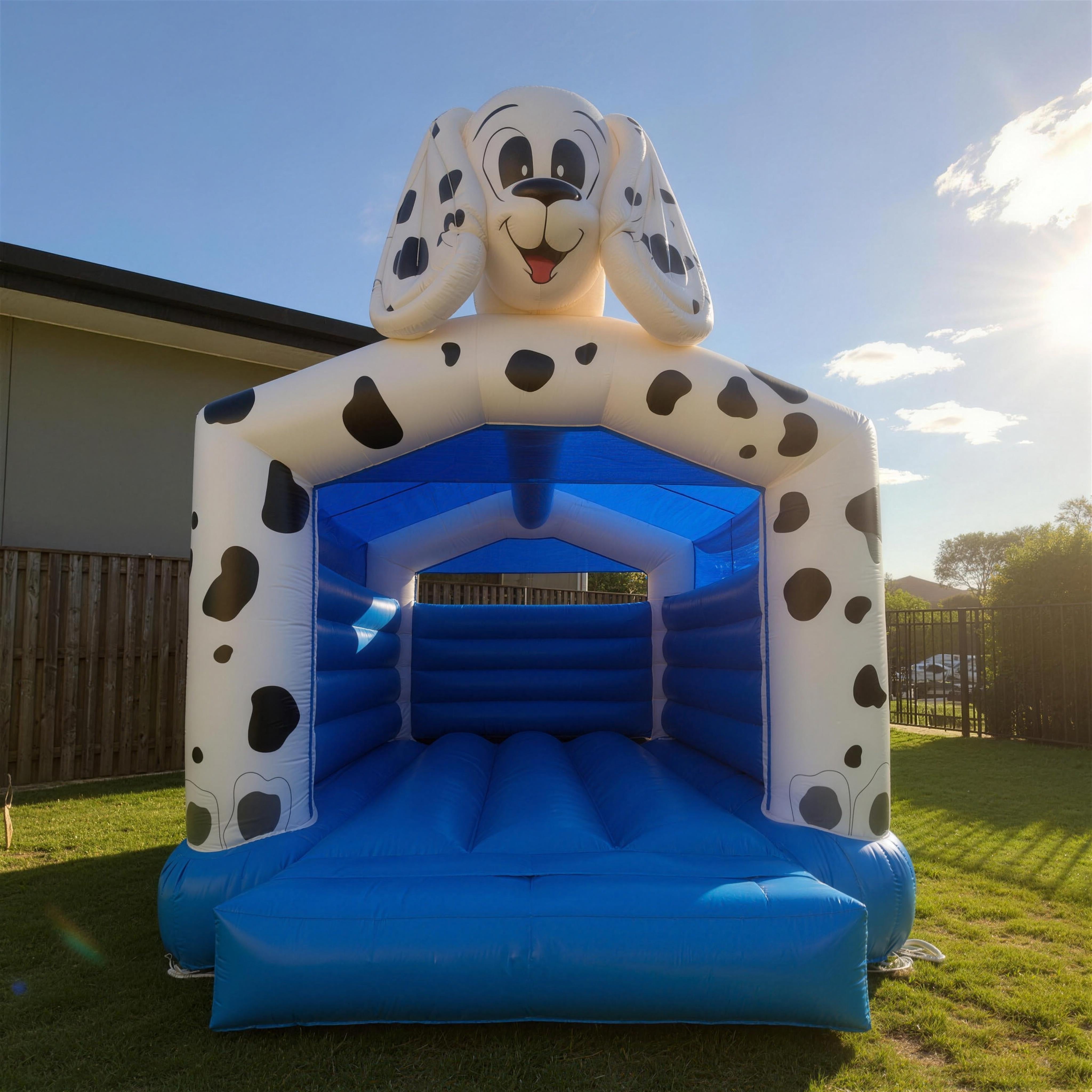 Low-angle view of the 101 Dalmatians jumping castle's dog-head topper against a clear blue sky.