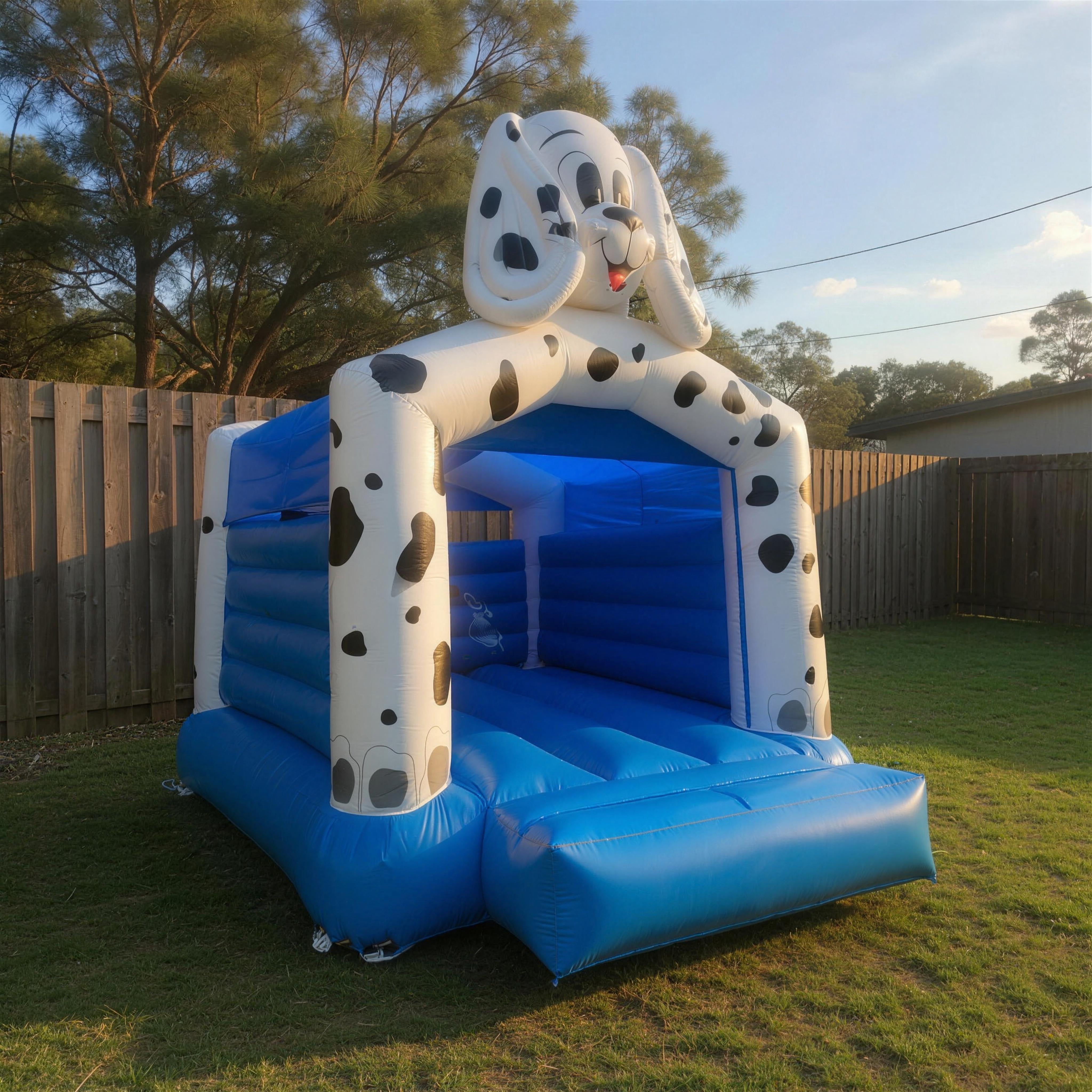 Side profile of the 101 Dalmatians jumping castle in a Central Coast backyard, golden-hour light.
