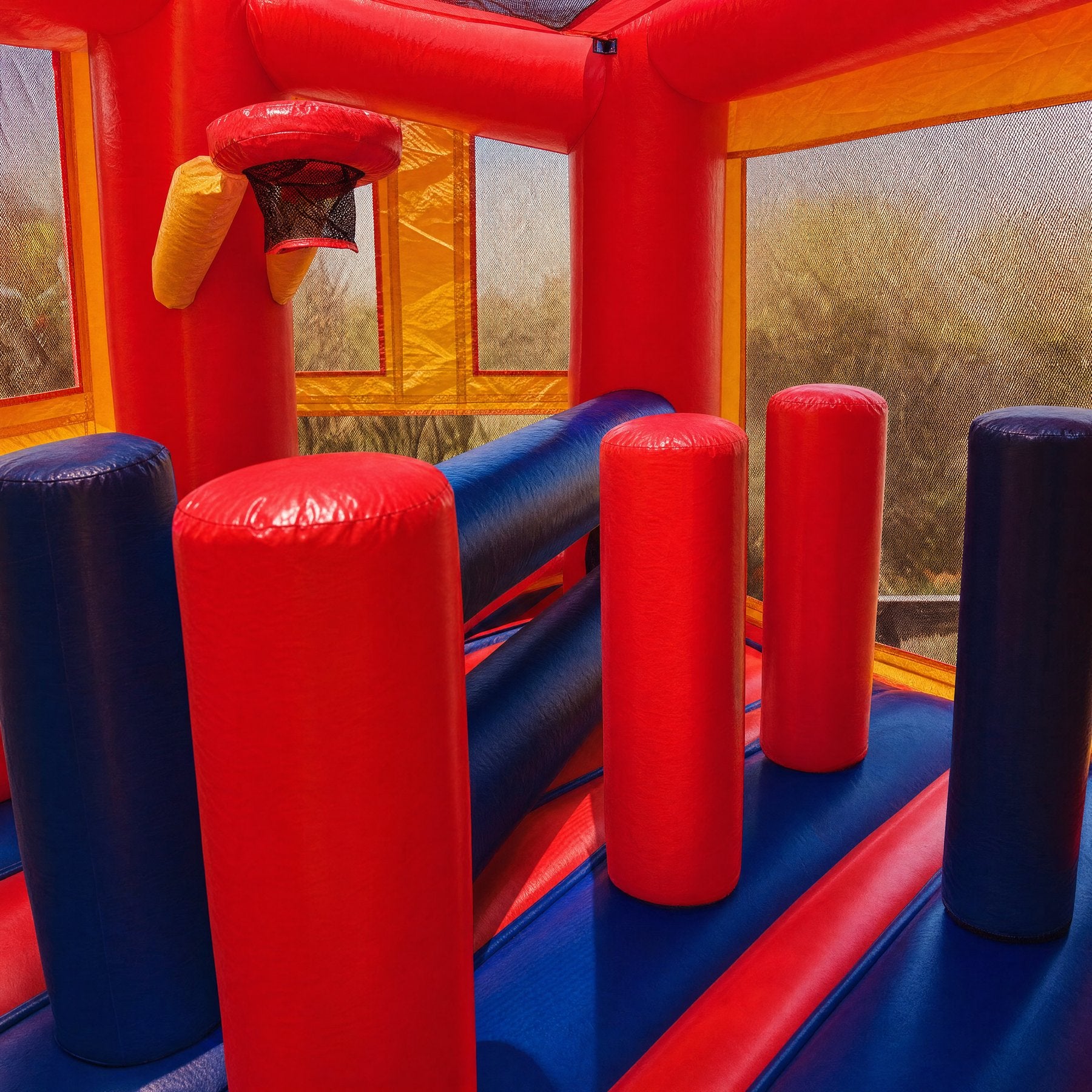 Basketball hoop and foam obstacle bollards inside the 5in1 Banner Castle Combo
