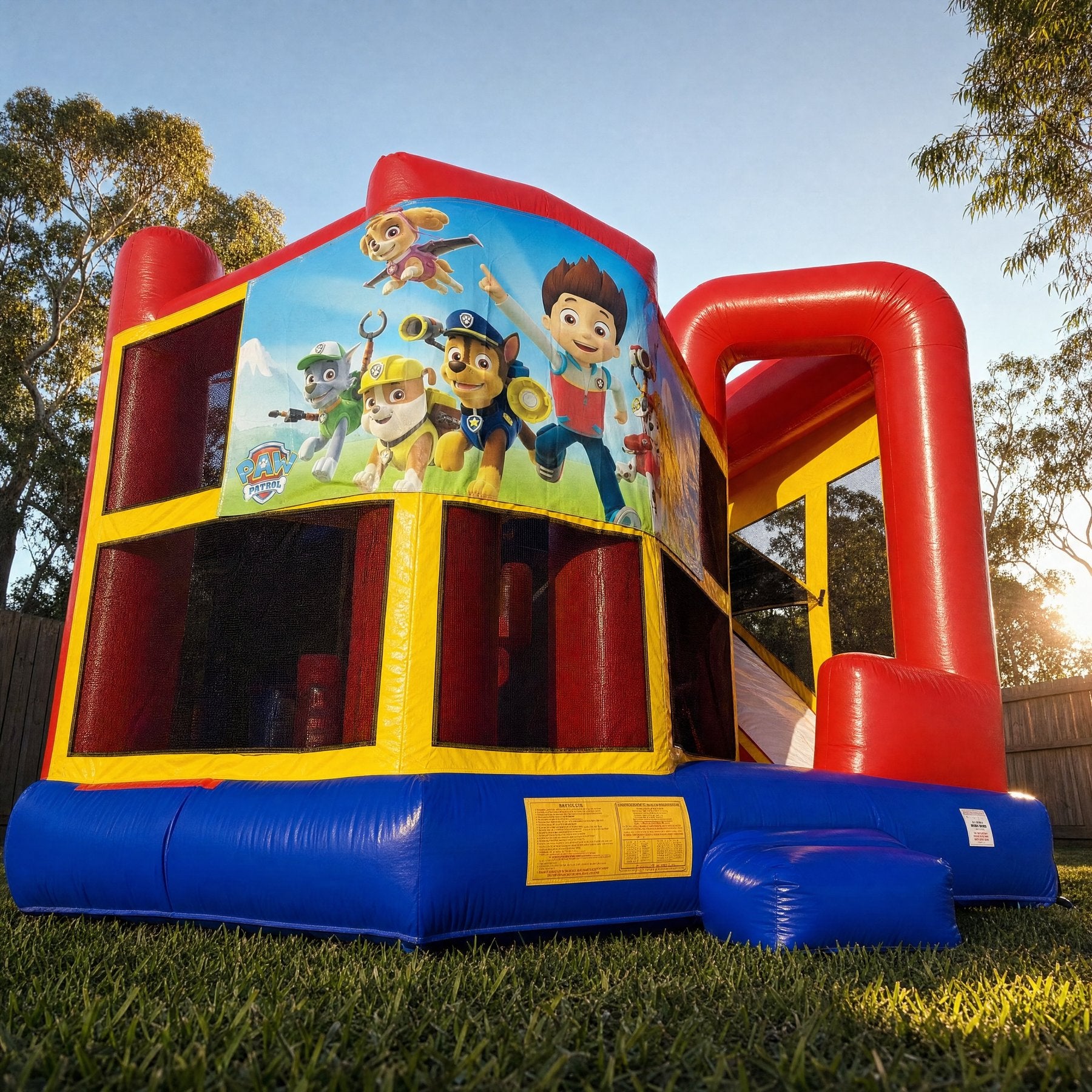 Low angle view looking up at the 5in1 Banner Castle Combo (shown with the Paw Patrol banner, choose your theme at booking)