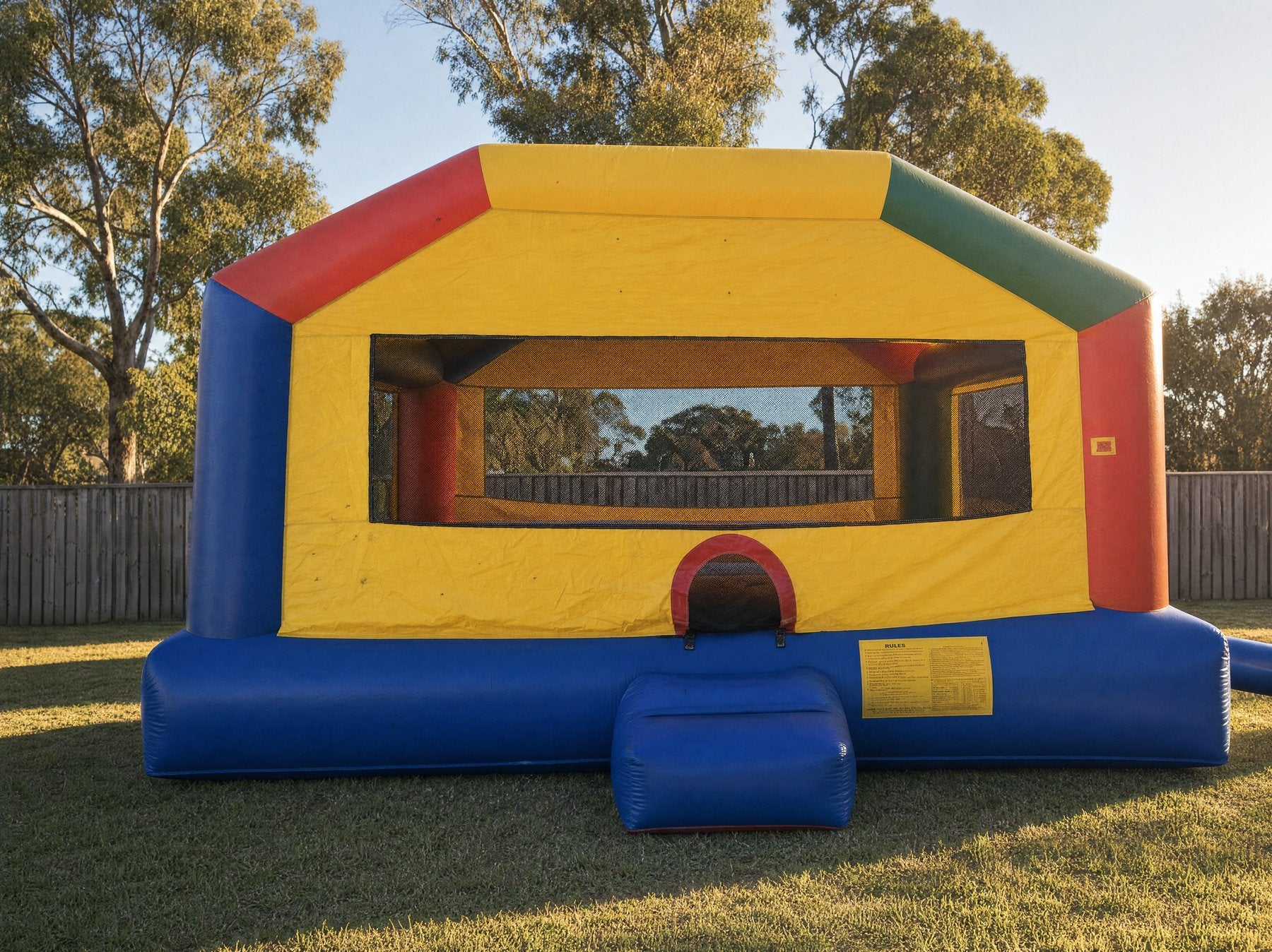 Wide straight-on view of an adult jumping castle with a large mesh window