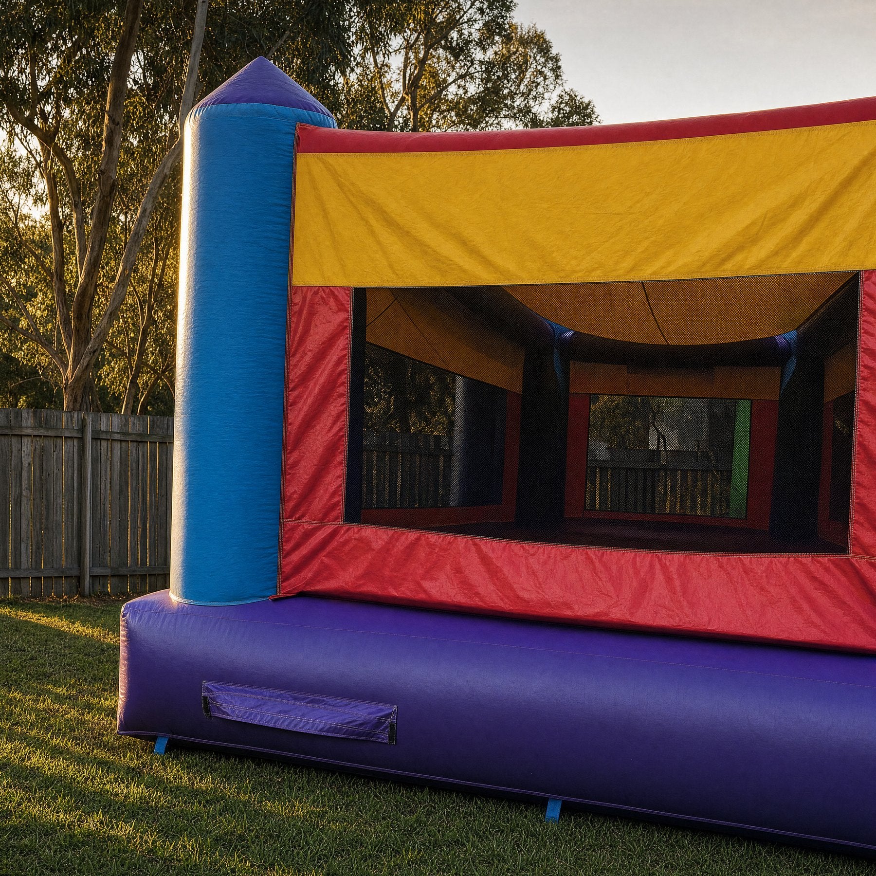 Side view of a purple jumping castle tower with a black mesh safety window
