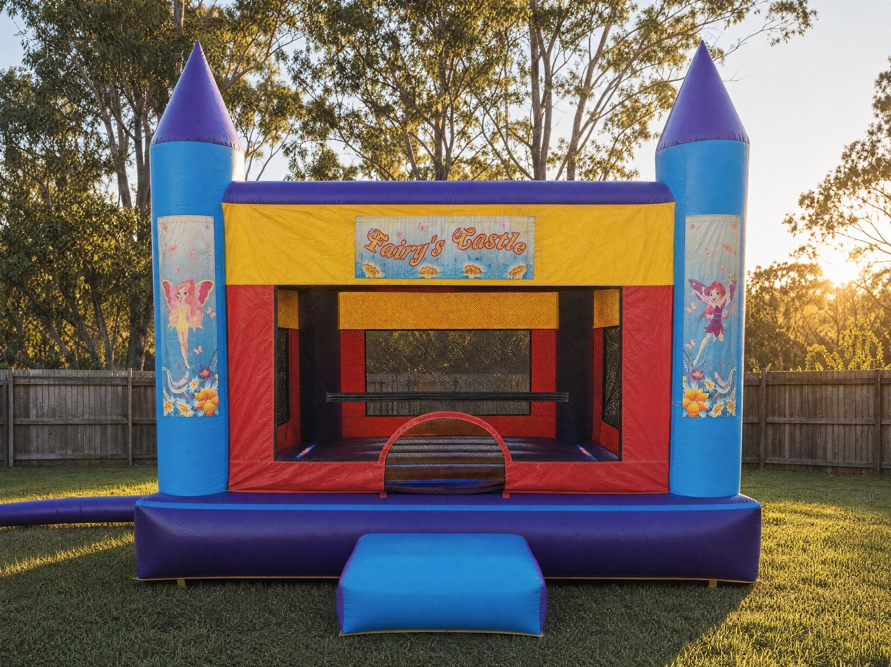 Wide straight-on view of a jumping castle with a Fairy's Castle printed banner