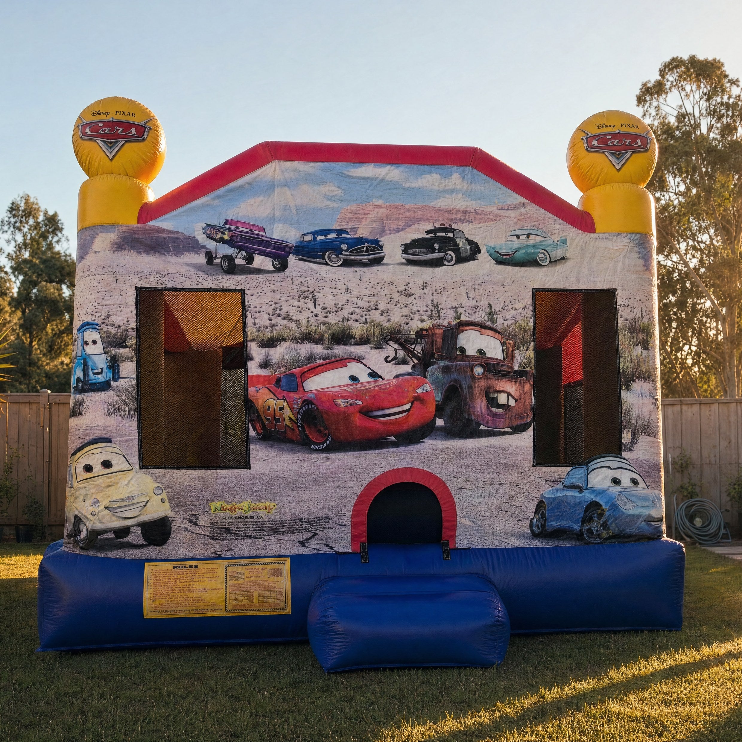 Cars C4 Combo jumping castle front view with the yellow Disney Pixar Cars logo toppers and Lightning McQueen artwork
