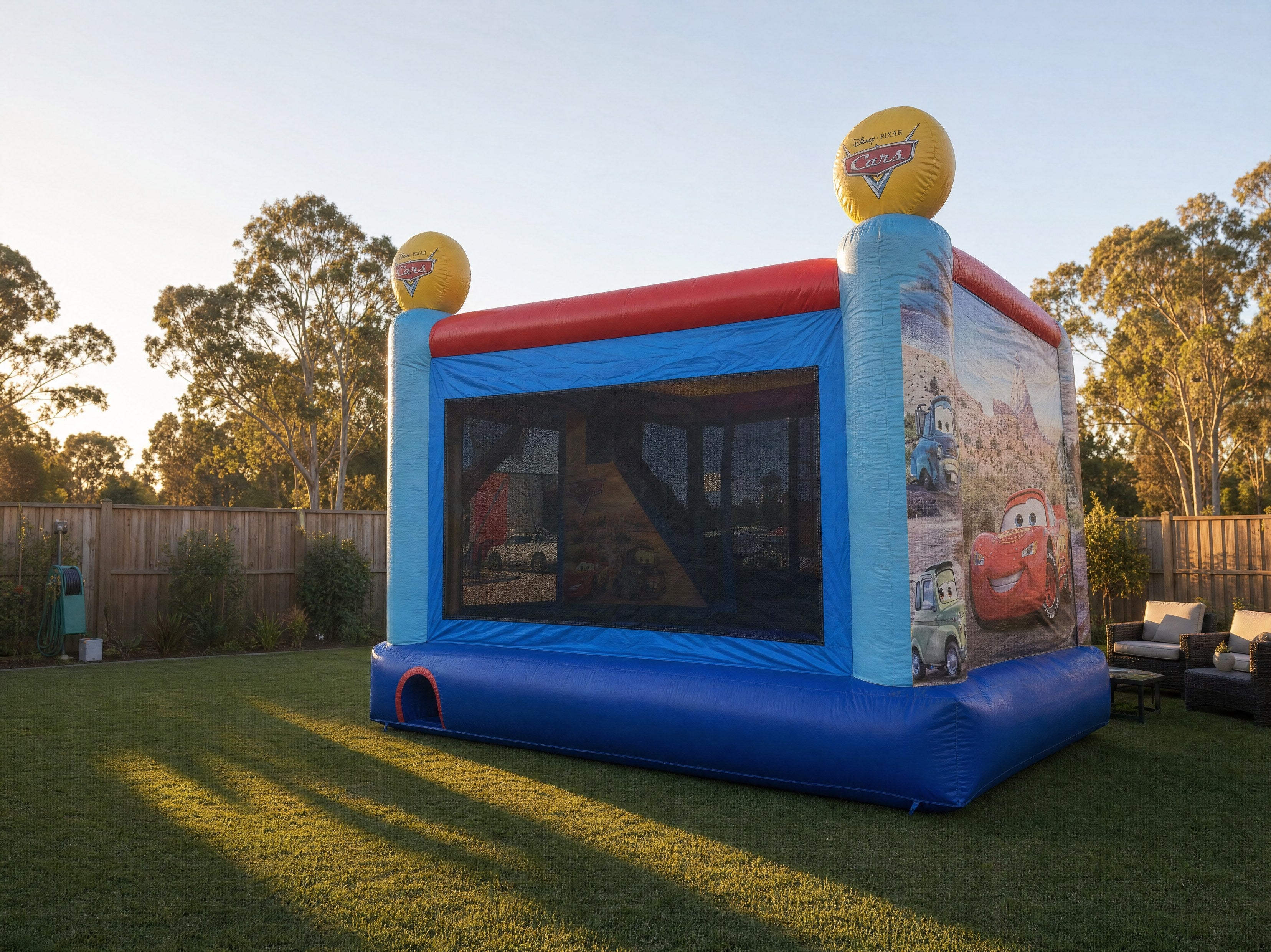 Side view of the Cars C4 Combo jumping castle showing yard scale in a Central Coast backyard