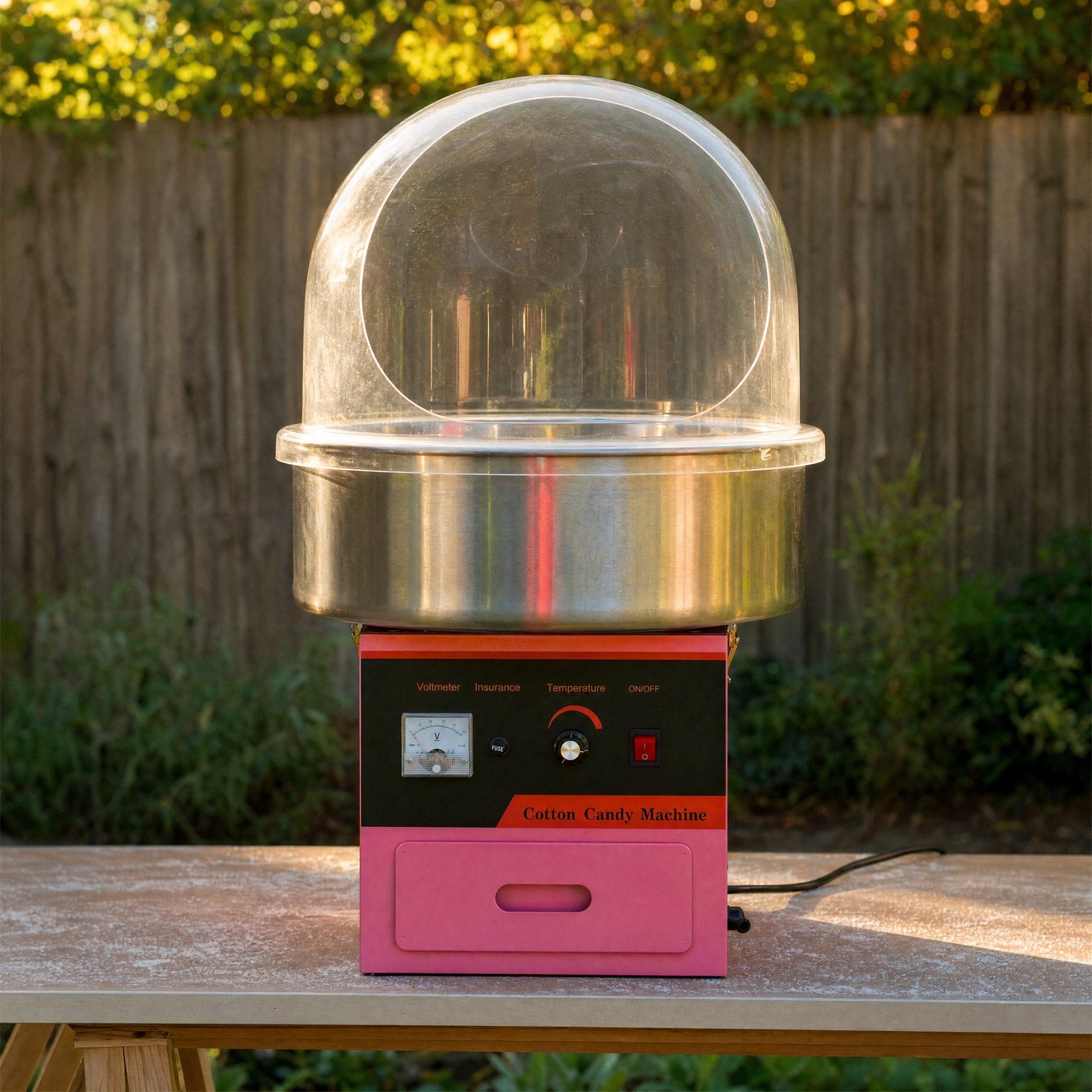 Front-facing view of a commercial fairy floss machine control panel and dome at a party