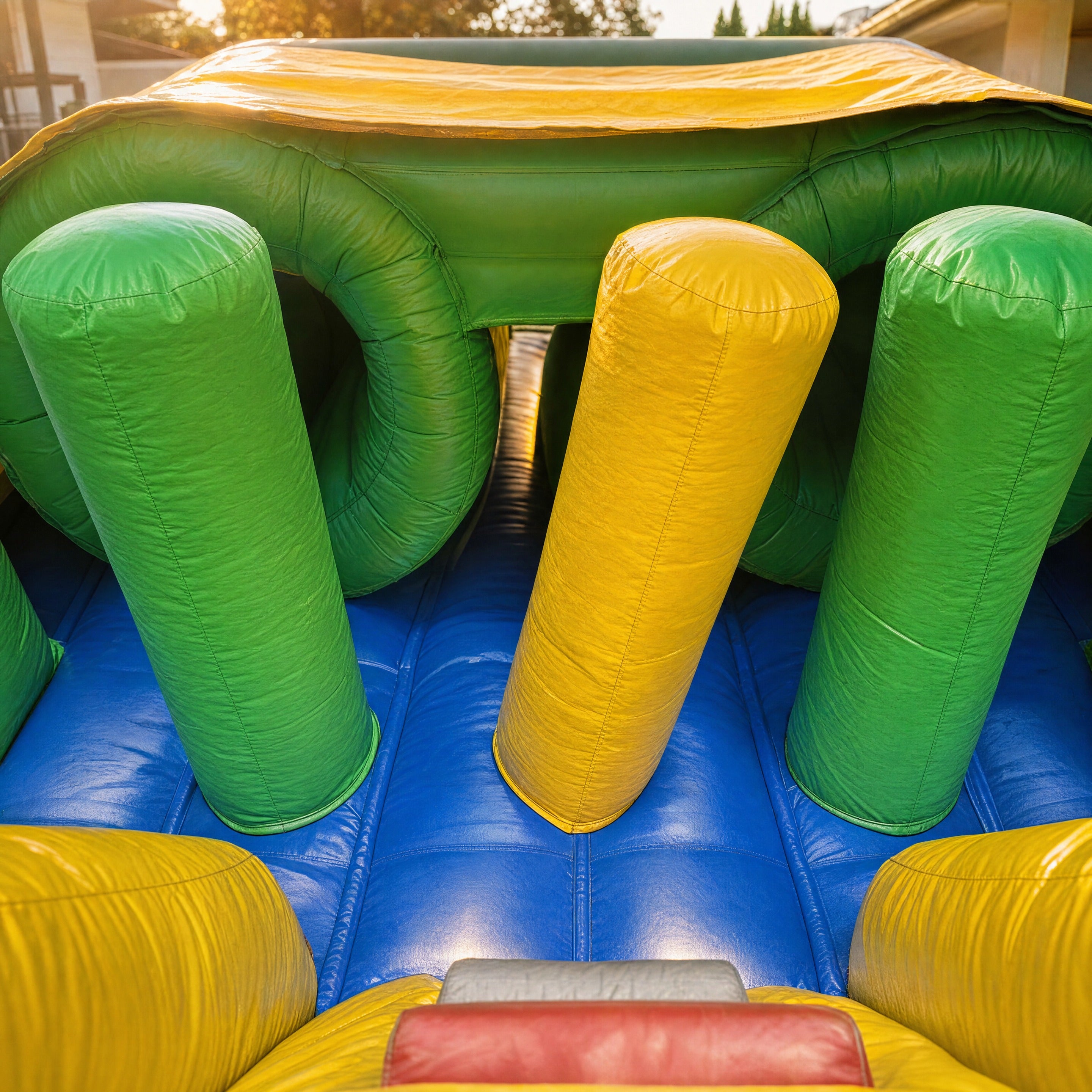 Green tunnel arch and yellow obstacle poles inside the Footy Obstacle Challenge