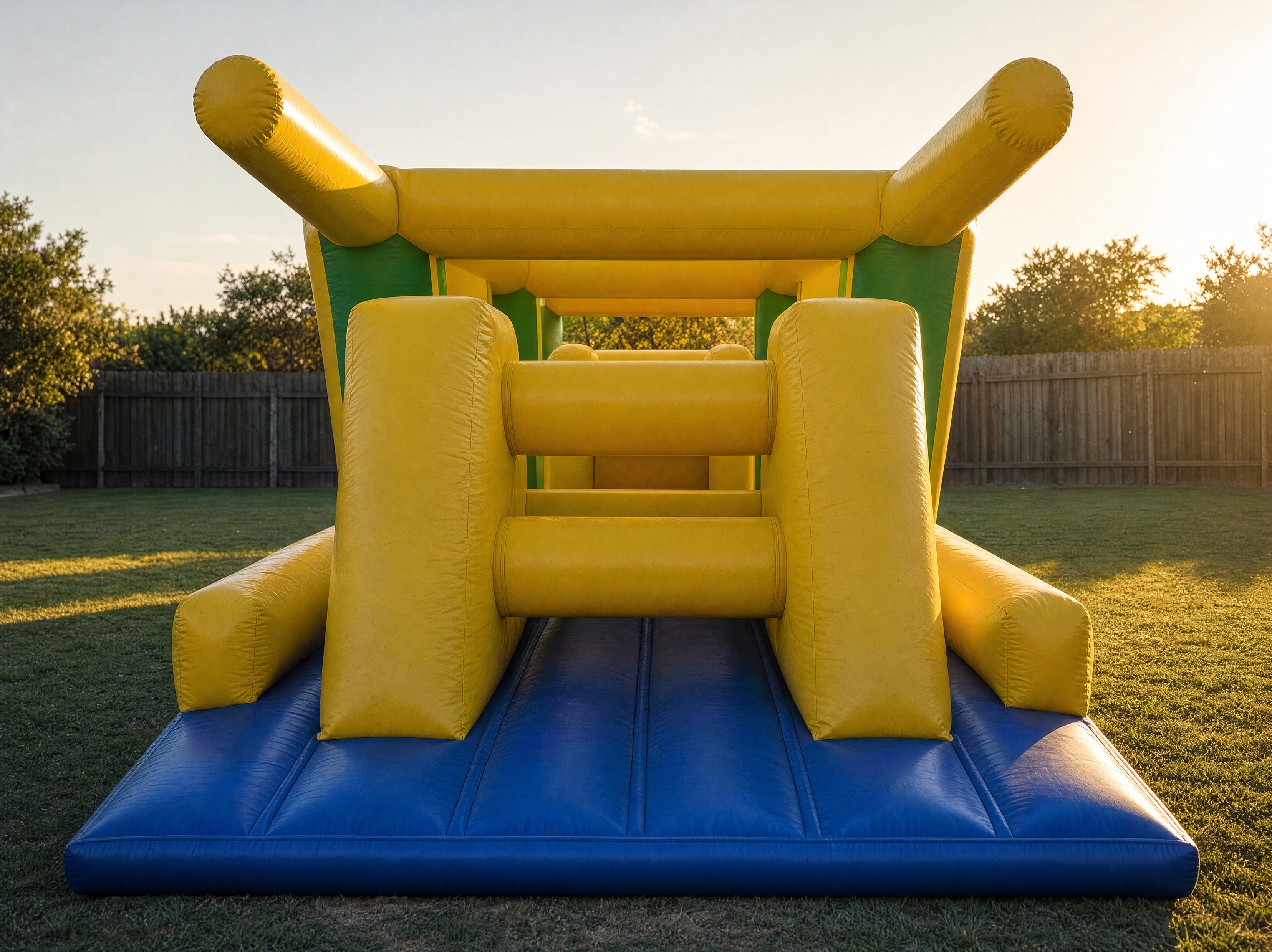 Wide front view of the Footy Obstacle Challenge entrance archway in a backyard