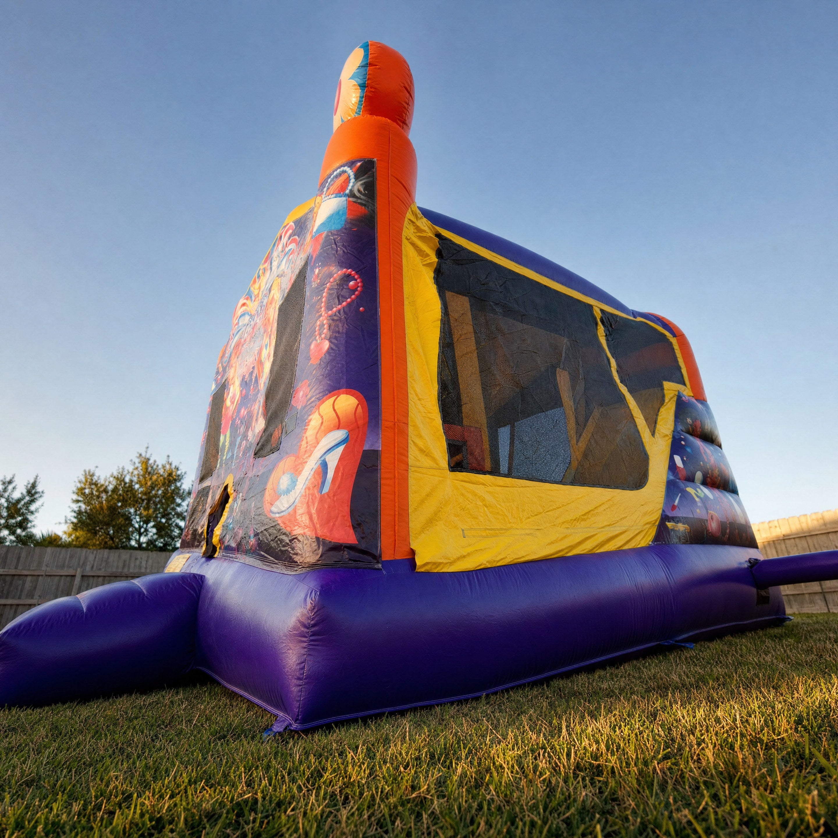 Low angle view looking up at a jumping castle's orange ball toppers against blue sky