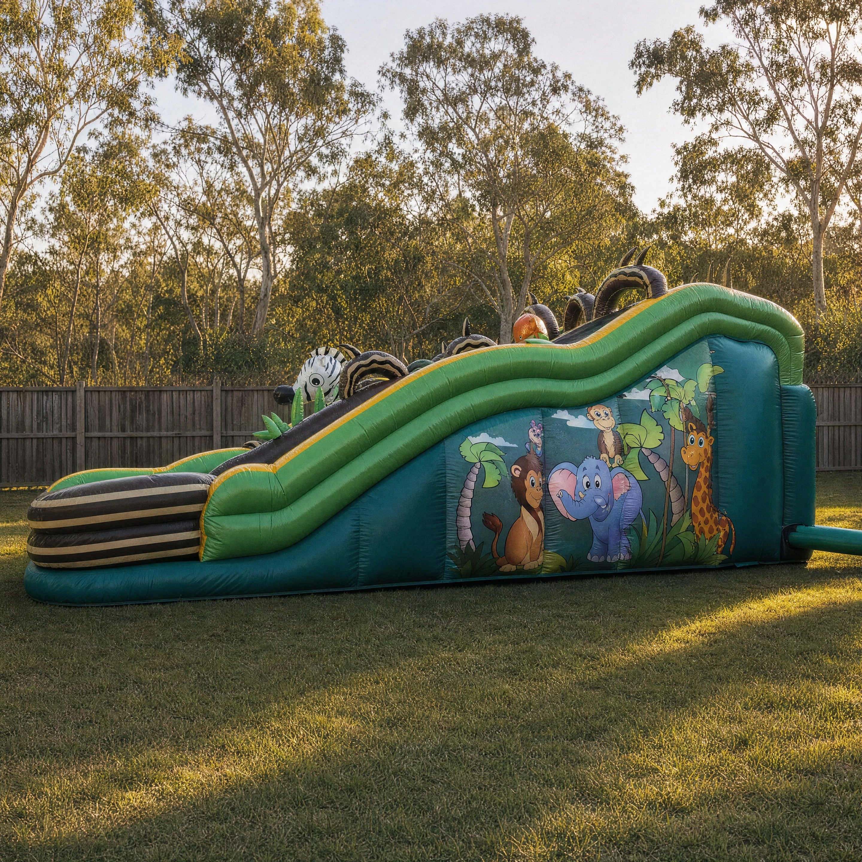 Jungle Double Lane Water Slide Hire - side profile showing the full length and jungle mural panel
