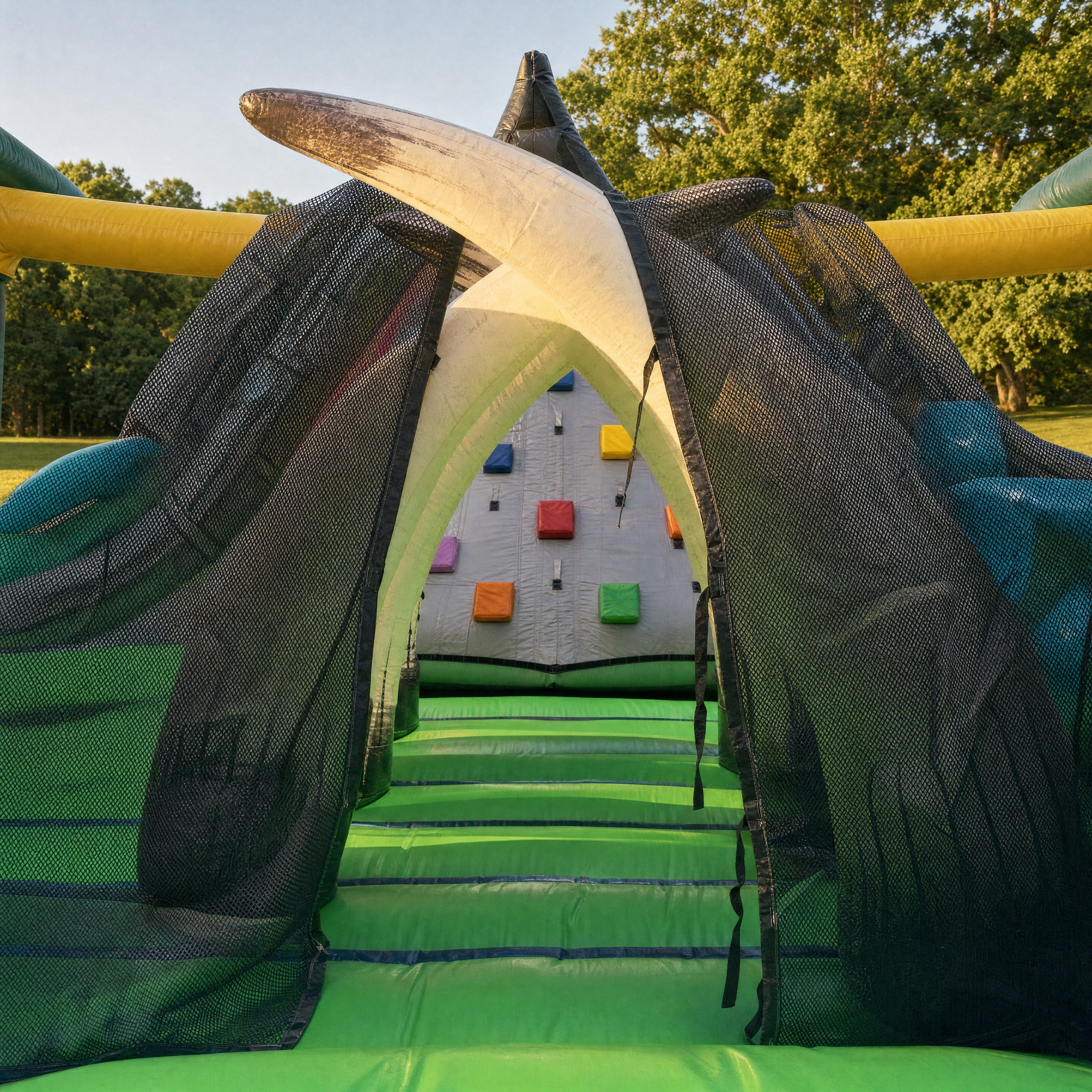 View through the tusk archway toward the climbing wall inside the Jurassic Adventure Obstacle