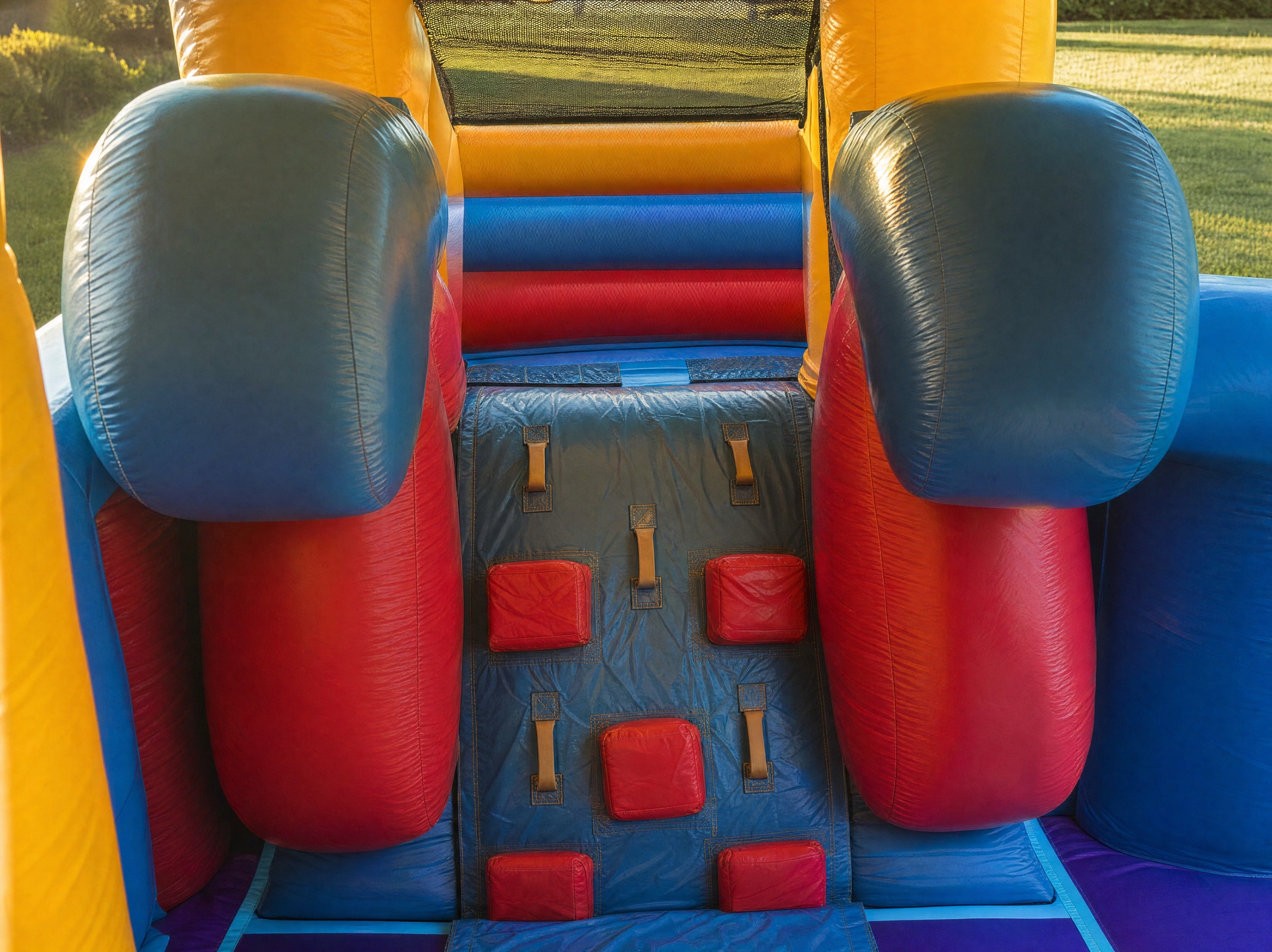 Interior view through the doorway of the Module Front Slide Banner Castle Combo showing the climbing wall and basketball net