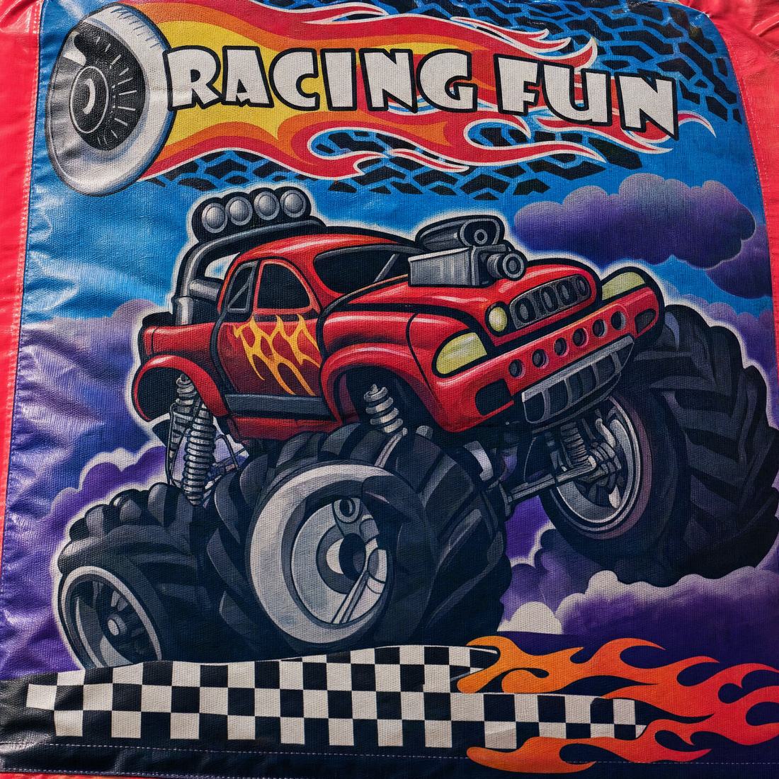 Close view of the RACING FUN wordmark and monster truck artwork on the castle panel