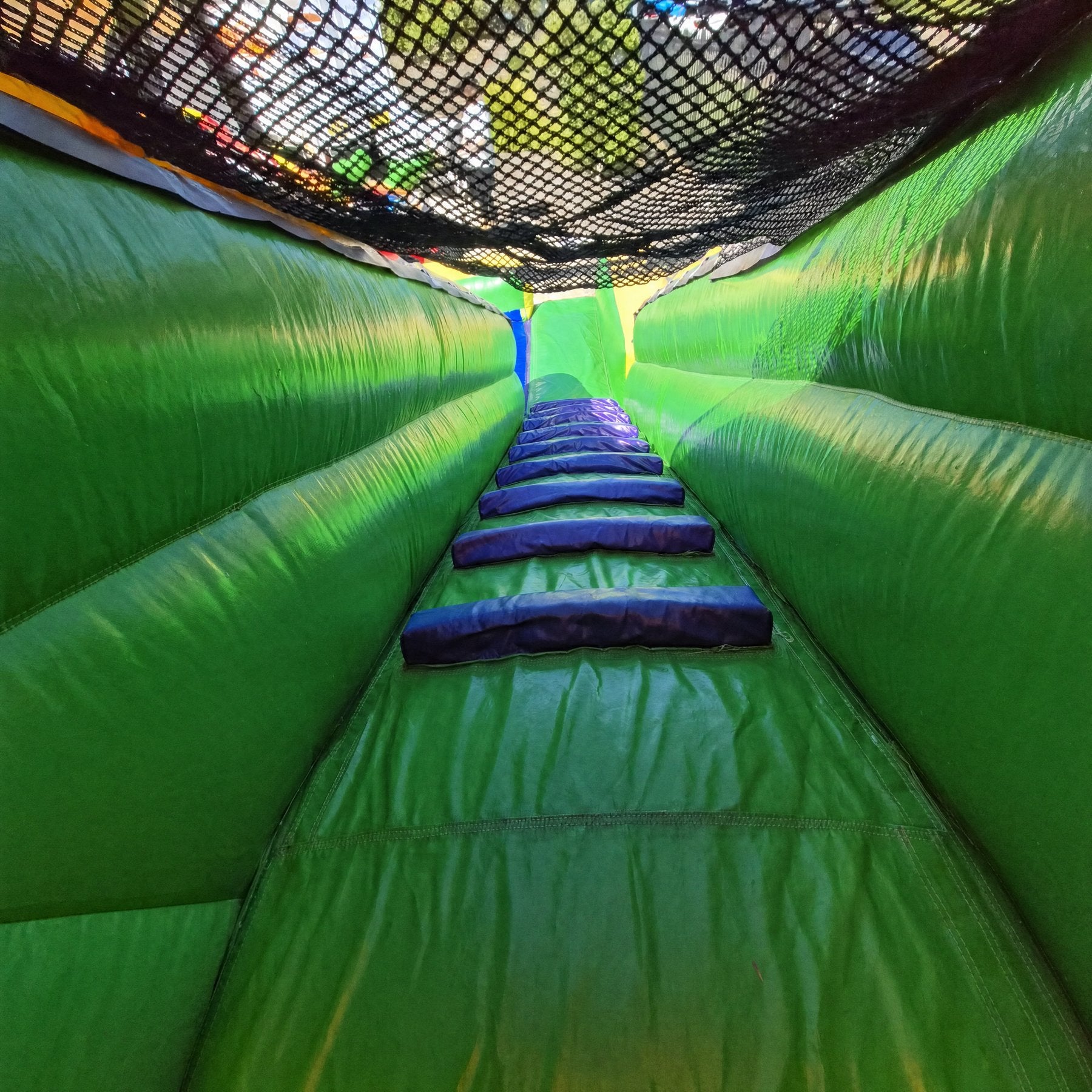 Interior view of the SS Splash Water Slide climbing tunnel with safety netting