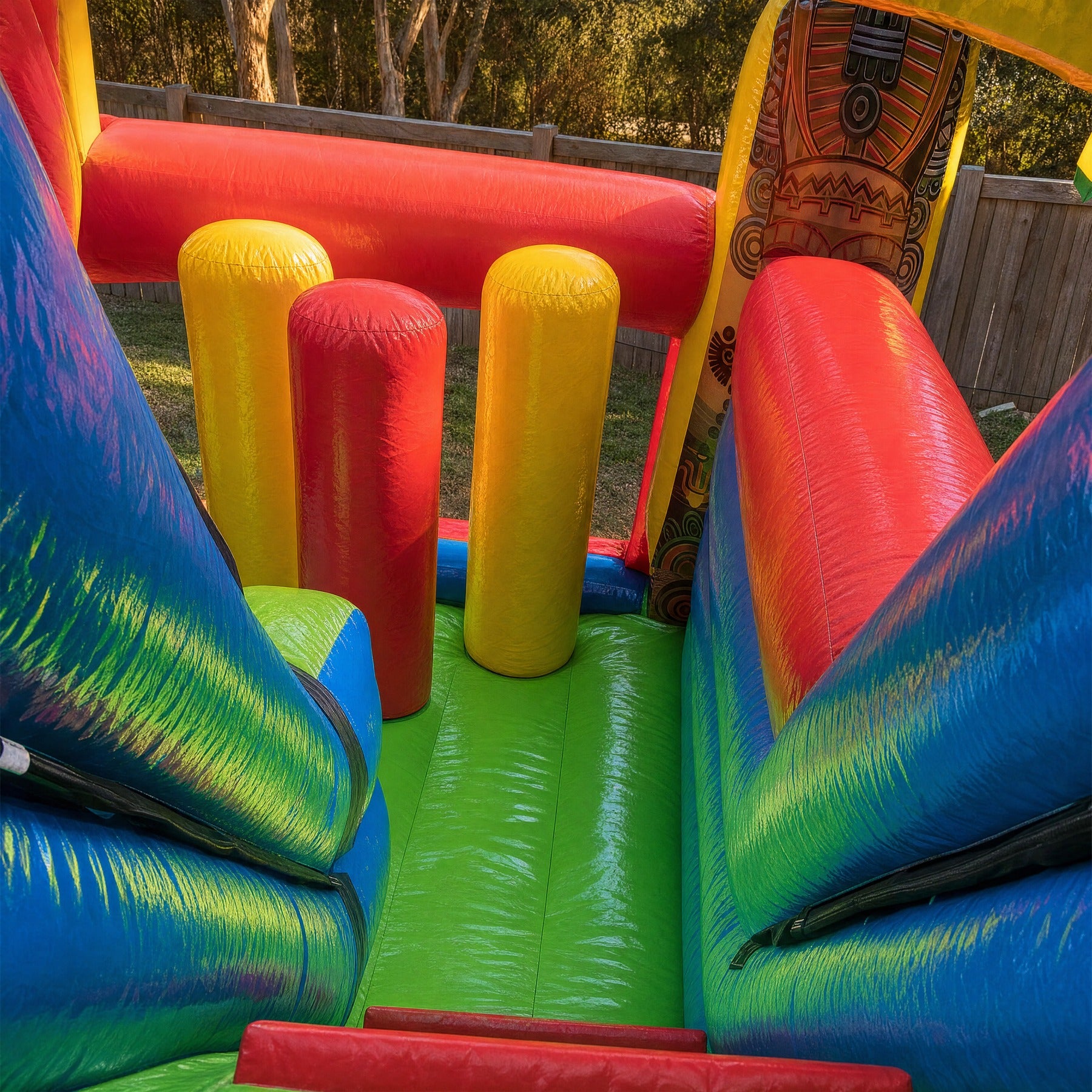 Padded bumper towers inside the Tiki Island inflatable obstacle course