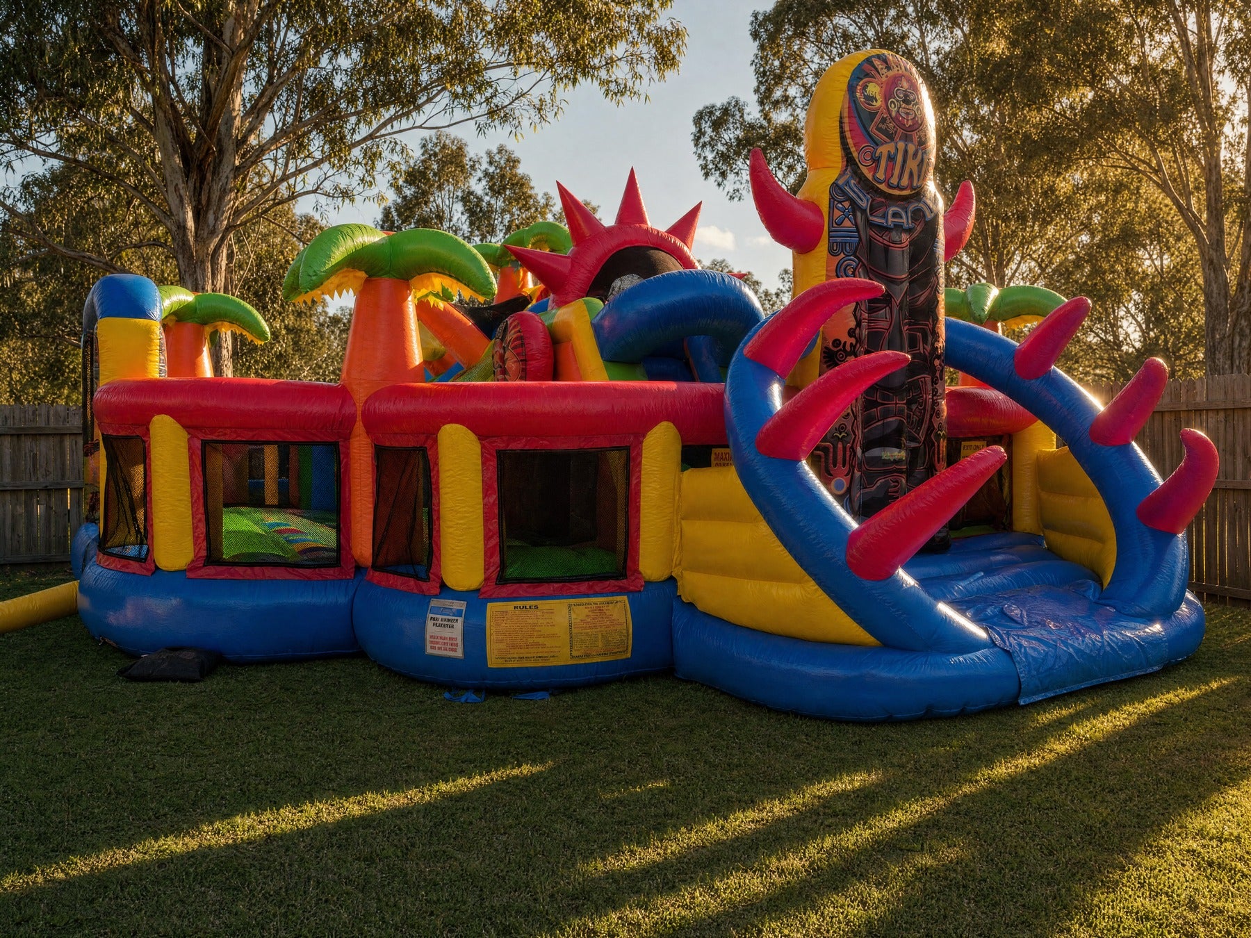 Wide scale view of the Tiki Island inflatable obstacle course in a backyard