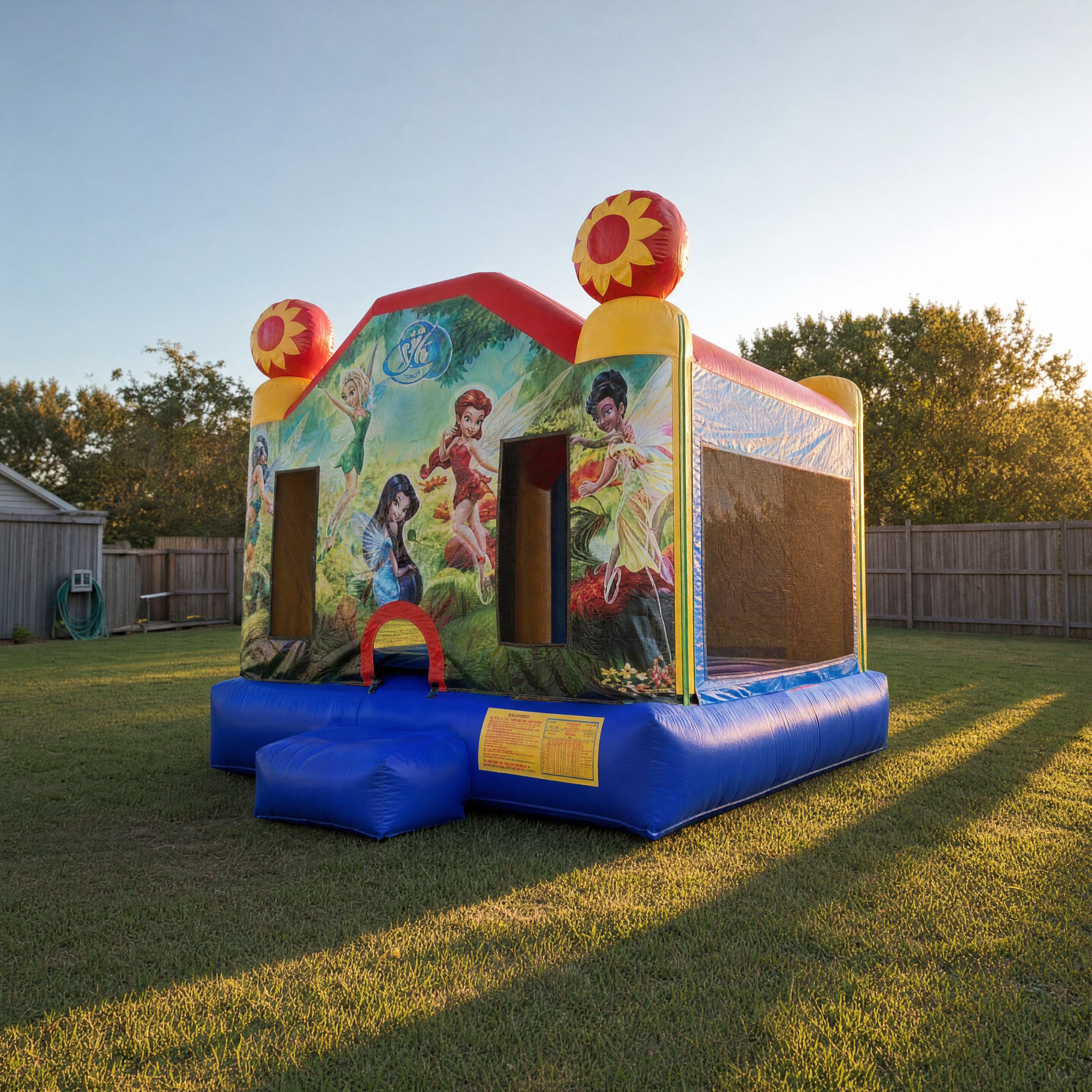 Tinkerbell Jumping Castle side angle view showing fairy artwork and backyard depth
