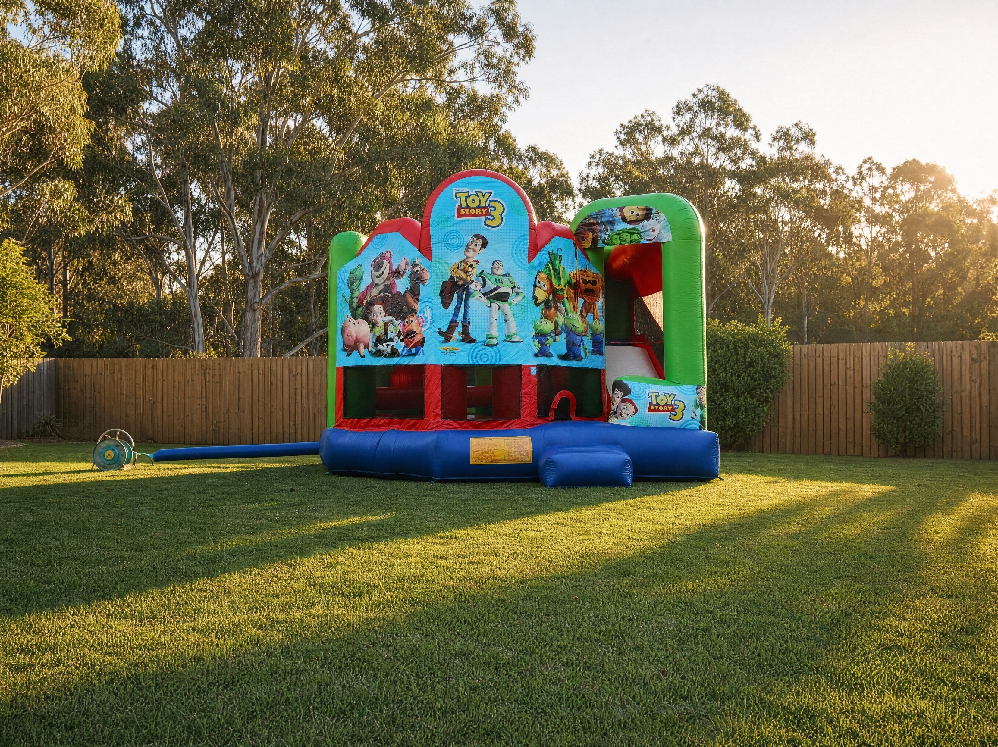 Toy Story 5in1 Combo Castle Hire, golden hour backyard setup showing the full Toy Story 3 combo castle