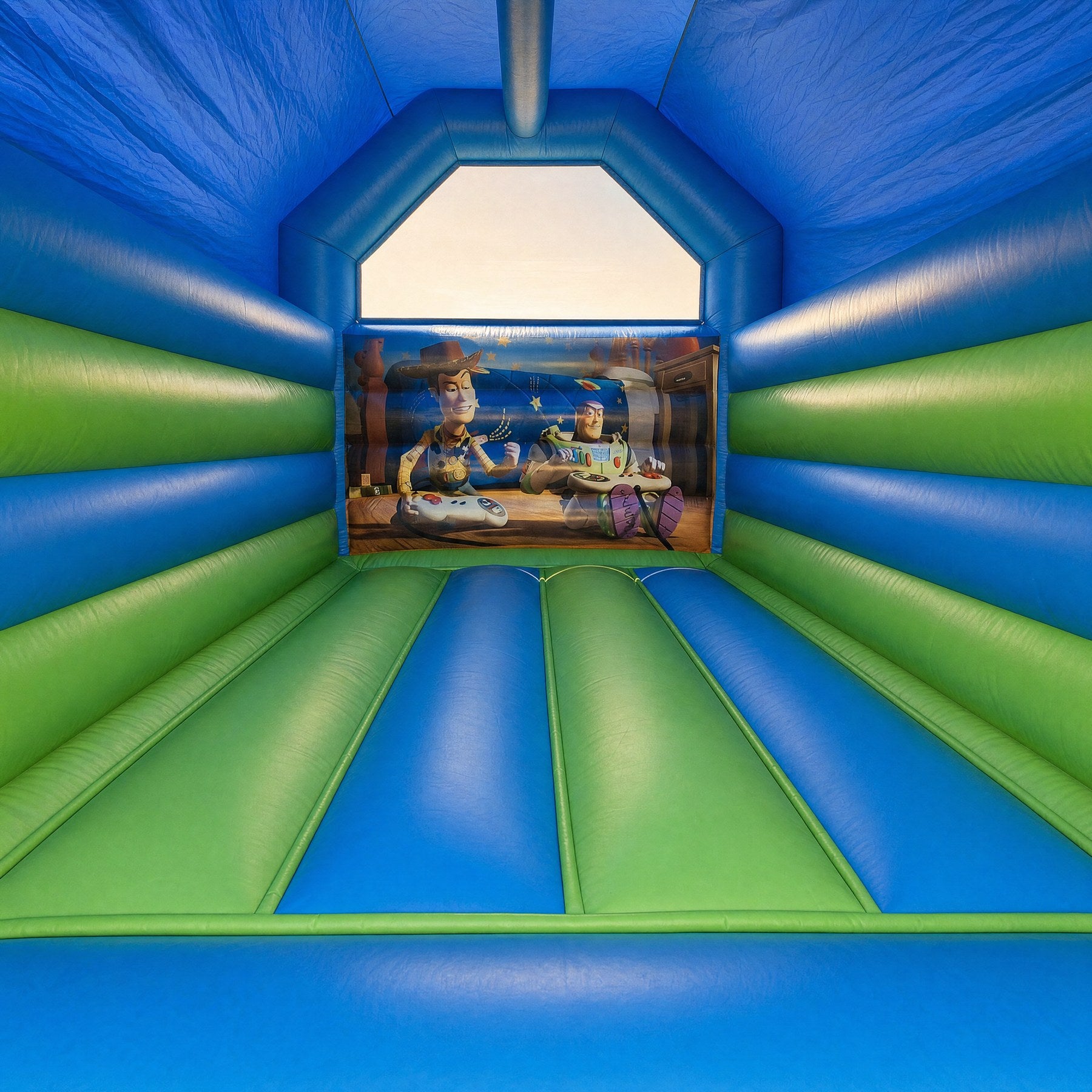 Interior view of Toy Story jumping castle showing the printed Woody and Buzz mural