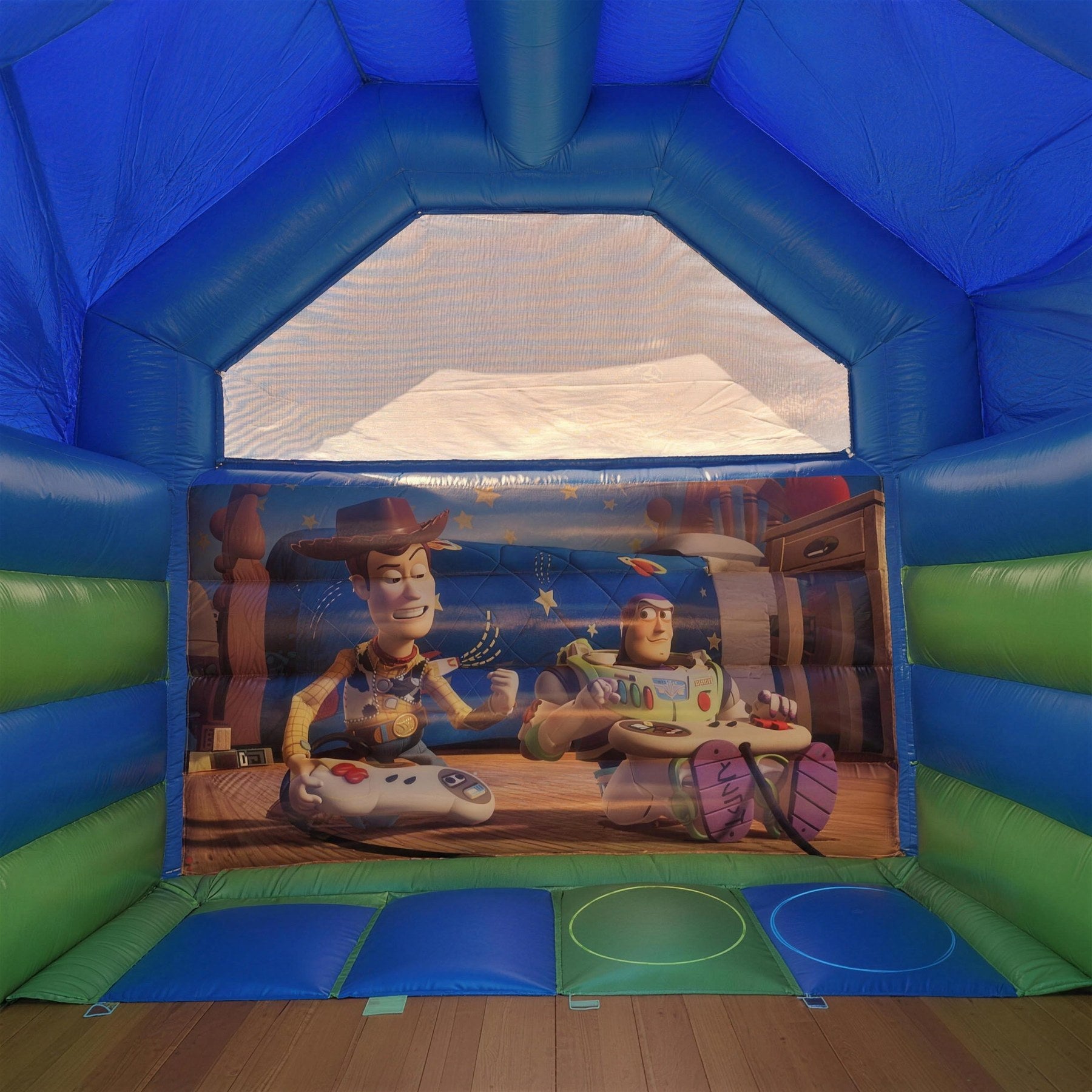 Toy Story jumping castle under a shady tree with dappled afternoon light in a backyard