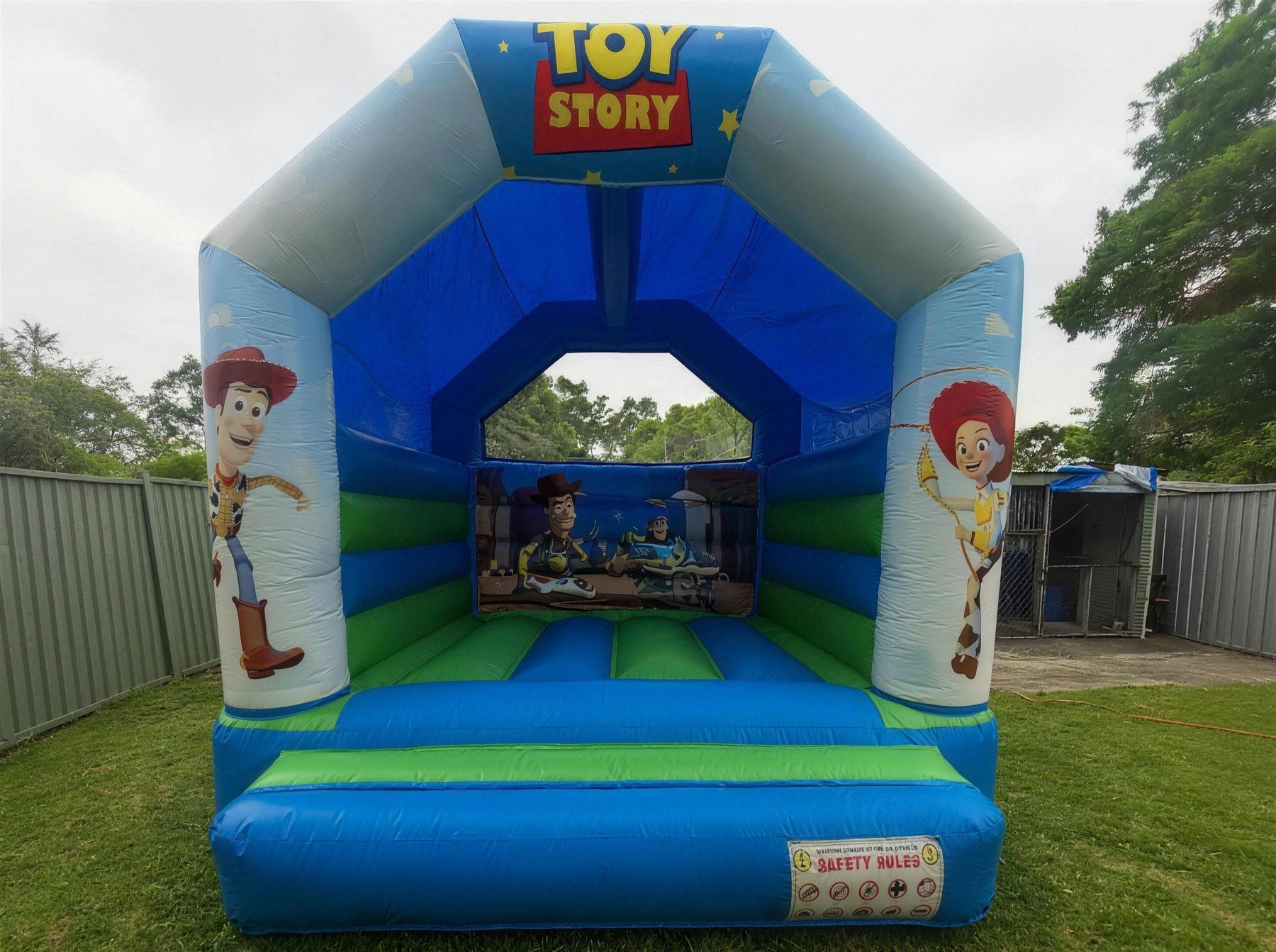 Toy Story open jumping castle with Woody and Jessie artwork set up in a Central Coast backyard