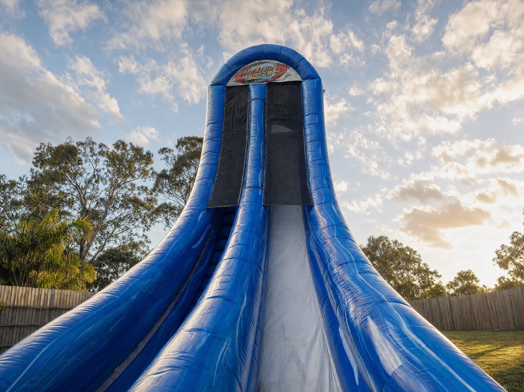 Vertical Screamer Water Slide archway and top platform showing the printed logo, wide view