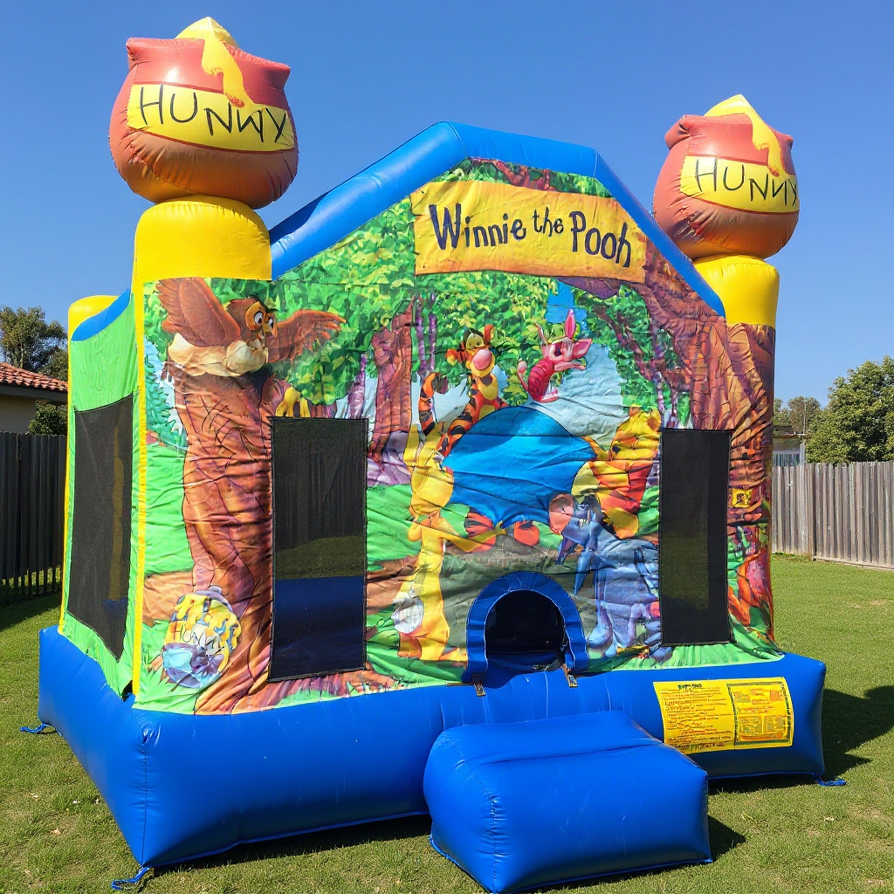 Close view of the Winnie the Pooh jumping castle entrance and honey pot topper