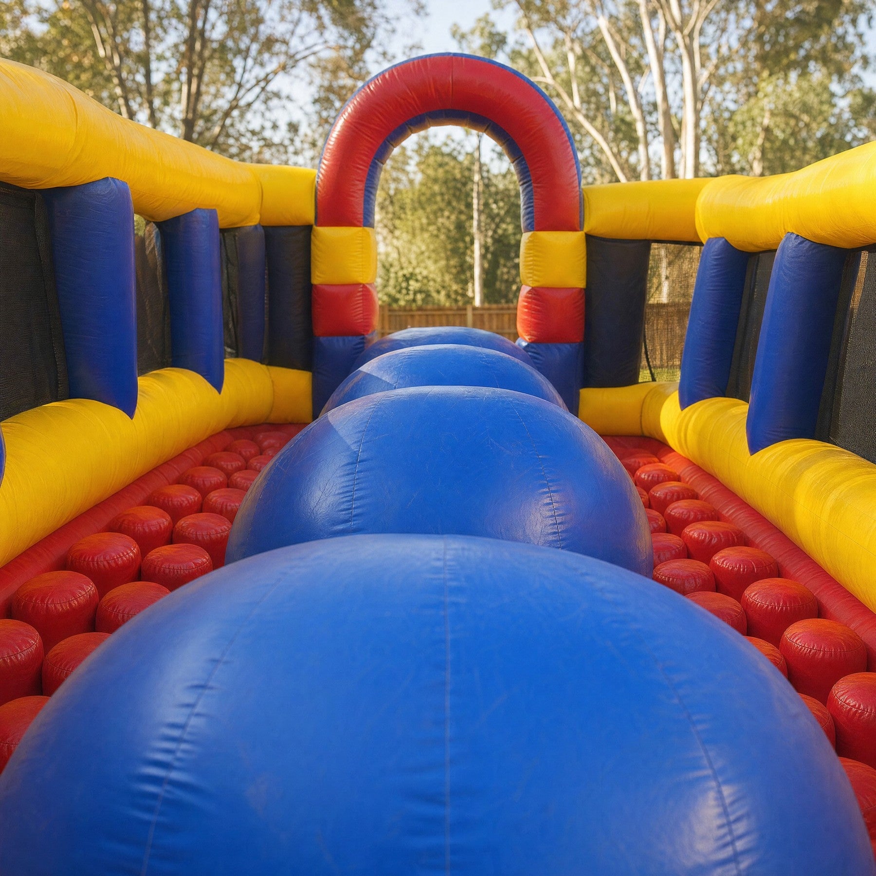 Giant blue rollers inside the Wipe Out Inflatable padded obstacle lane