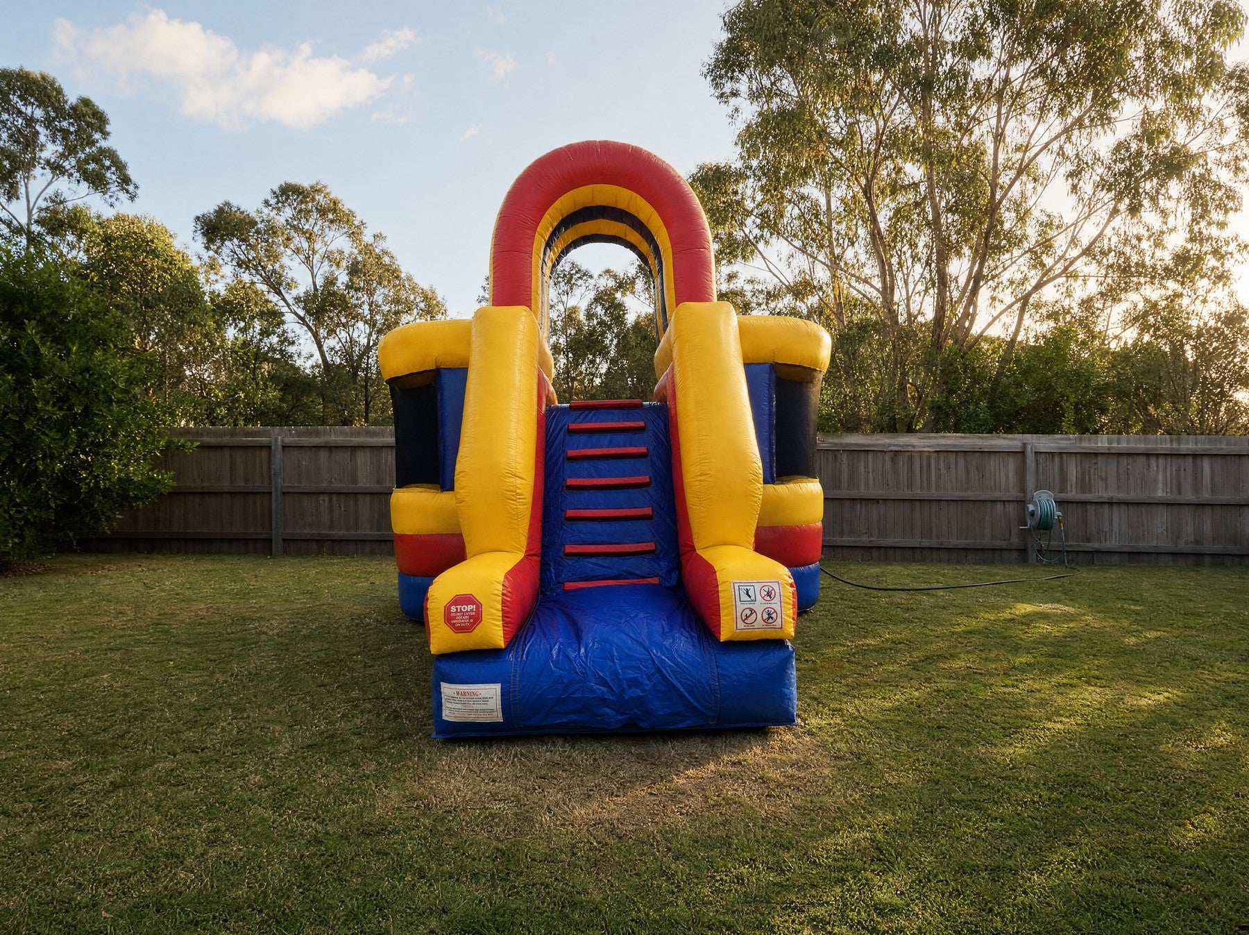 Wide scale view of the Wipe Out Inflatable game in a backyard