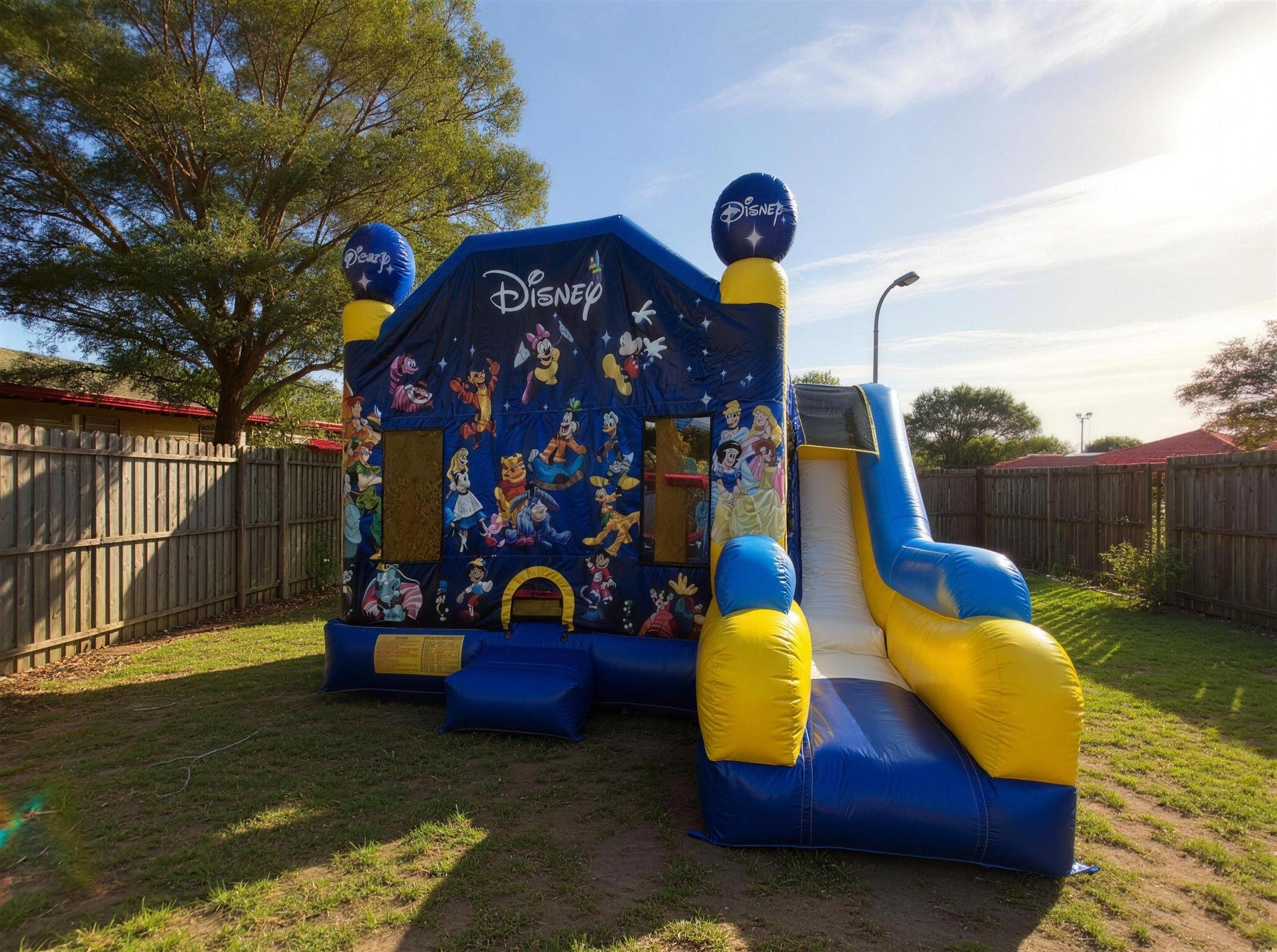 World of Disney C7 Combo castle hire pulled back to show full size in an Australian backyard